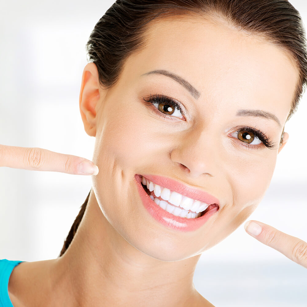 Woman showing her perfect straight white teeth.